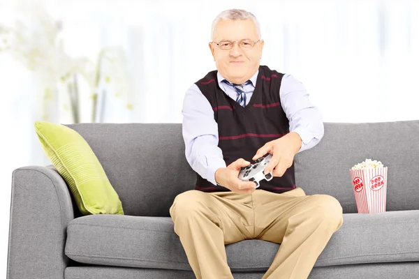 Senior man speelt videospelletjes — Stockfoto