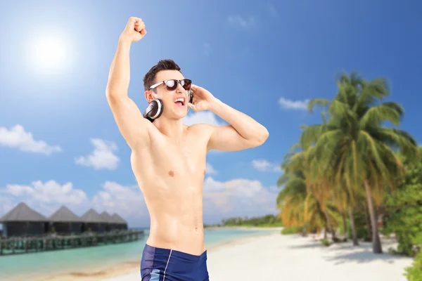 Guy listening music on beach — Stock Photo, Image