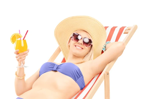 Mujer tomando el sol y sosteniendo cóctel — Foto de Stock