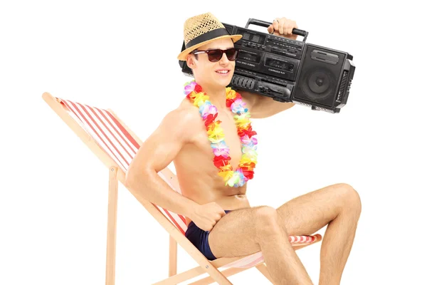 Male tourist on chair with boombox — Stock Photo, Image