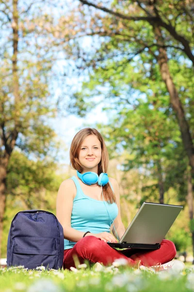 Kvinna i park och arbetar på laptop — Stockfoto