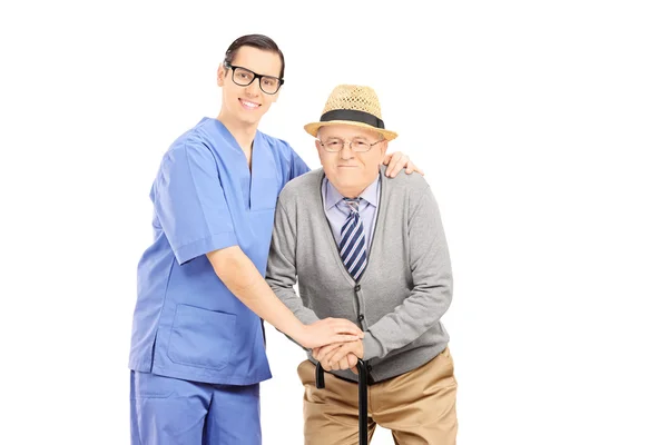 Sjukvårdspersonal hjälpa mannen med käpp — Stockfoto