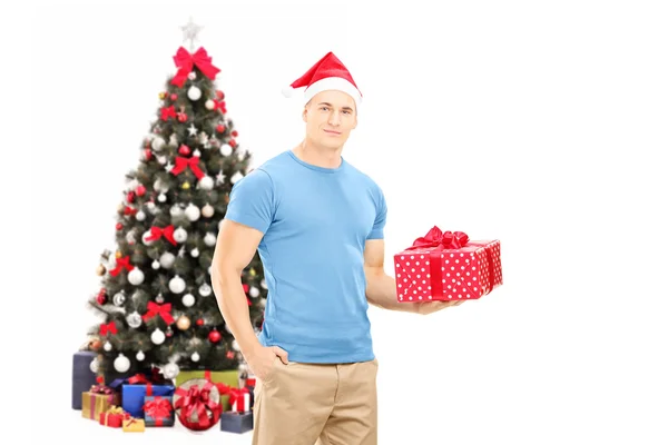 Ragazzo con il cappello di Babbo Natale in possesso regalo — Foto Stock