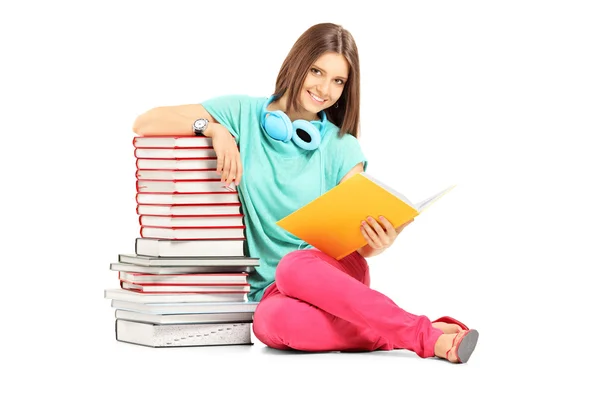 Vrouwelijke student in de buurt van vele boeken — Stockfoto