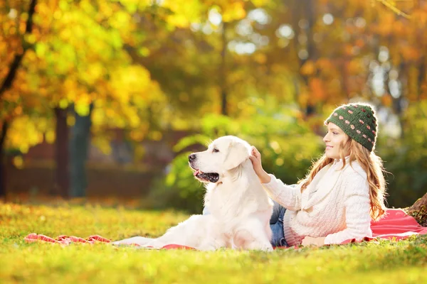 Femme couchée sur l'herbe avec chien — Photo