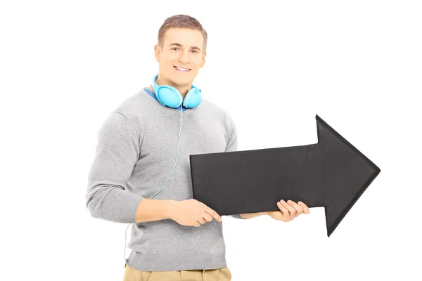 Guy with headphones holding arrow — Stock Photo, Image