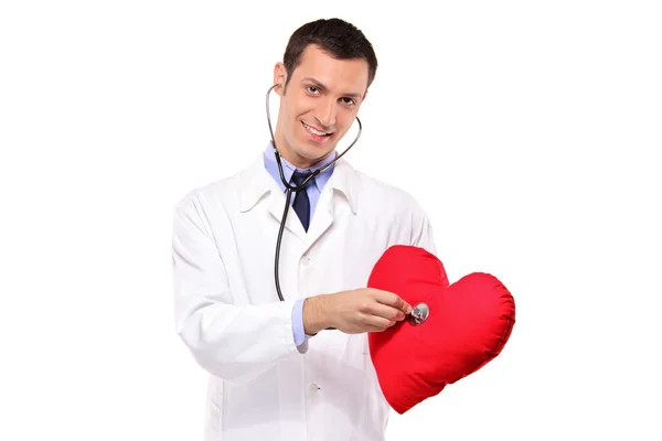 Médecin examinant oreiller en forme de coeur — Photo