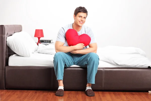 Man holding heart shaped pillow — Stock Photo, Image