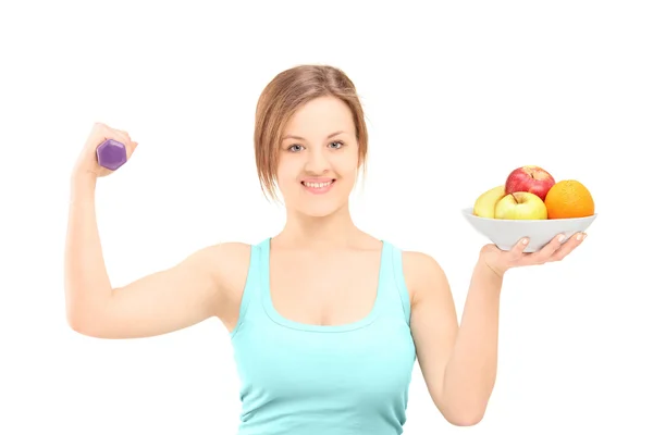 Mulher com haltere e frutas — Fotografia de Stock