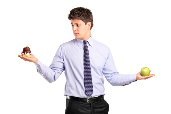 Man holding apple and cake — Stock Photo, Image