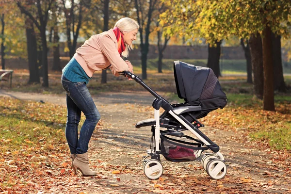 Moeder op zoek naar haar kind in de wandelwagen — Stockfoto