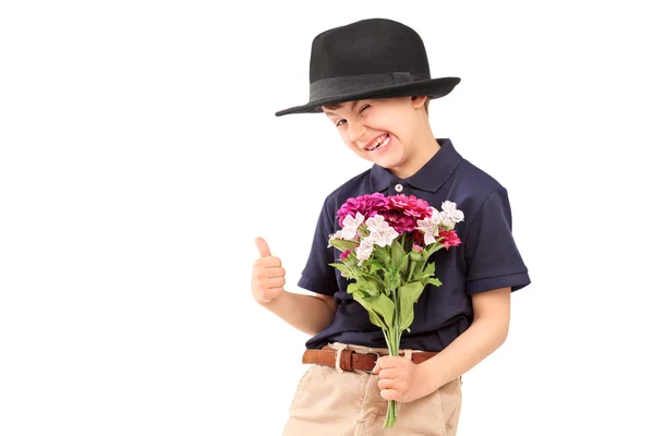 Милий маленький хлопчик з капелюхом тримає купу квітів — стокове фото