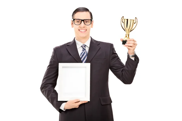 Чоловік тримає трофей і фоторамку — стокове фото