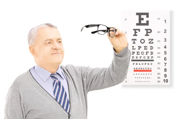 Senior  in front of eyesight test — Stock Photo, Image