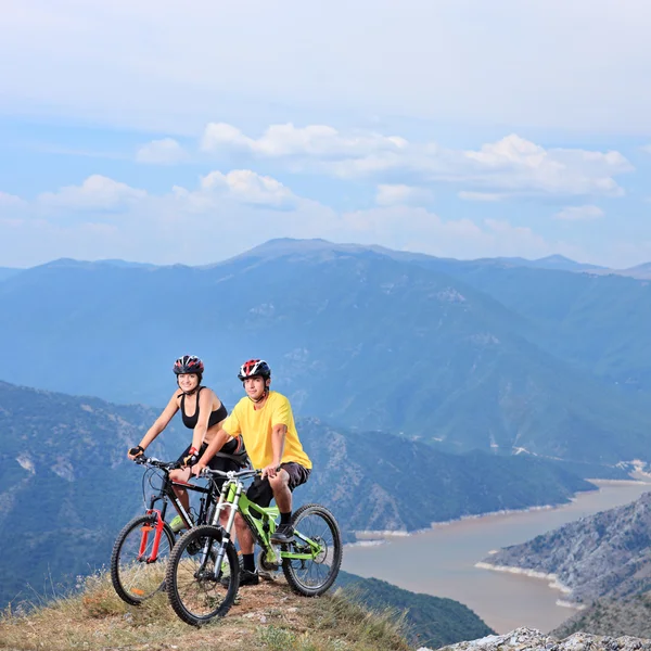 Vrouwelijke en mannelijke met mountainbikes — Stockfoto