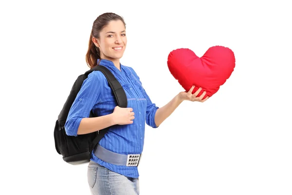 Kobieta trzyma poduszkę w kształcie serca — Zdjęcie stockowe
