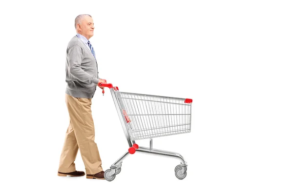 Cavalheiro empurrando um carrinho de compras vazio — Fotografia de Stock