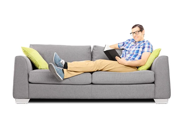 Male on a sofa reading a book — Stock Photo, Image