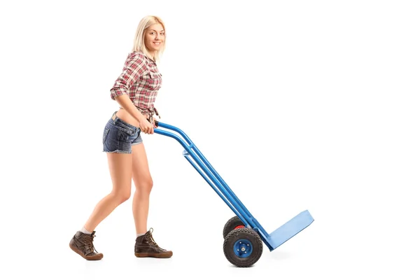 Vrouwelijke arbeider duwen handtruck — Stockfoto