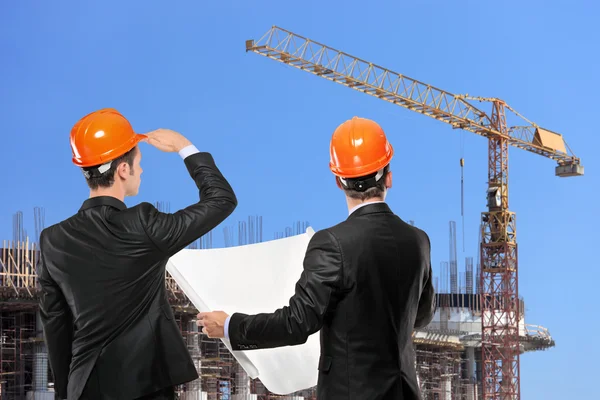 Voormannen kijken naar site in opbouw — Stockfoto