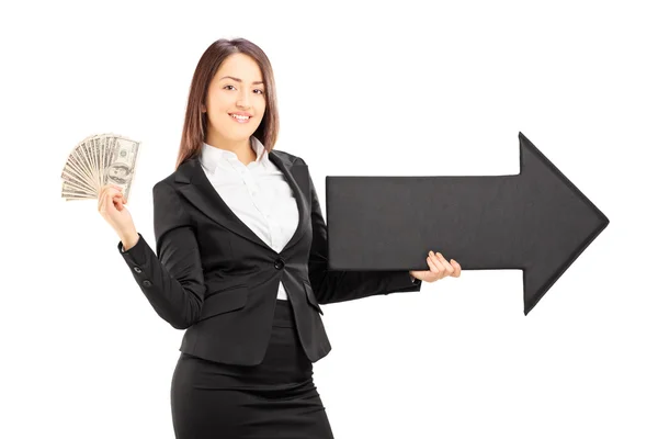 Businesswoman holding arrow and dollars — Stock Photo, Image