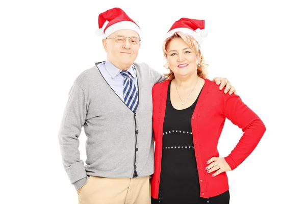 Pareja con sombreros de Santa Claus abrazándose — Foto de Stock