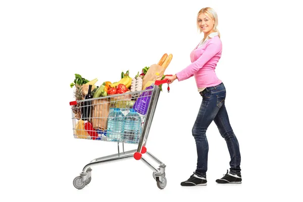 Feminino empurrando carrinho de compras — Fotografia de Stock