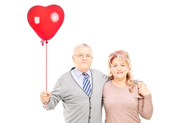 Casal no abraço segurando balão de coração — Fotografia de Stock