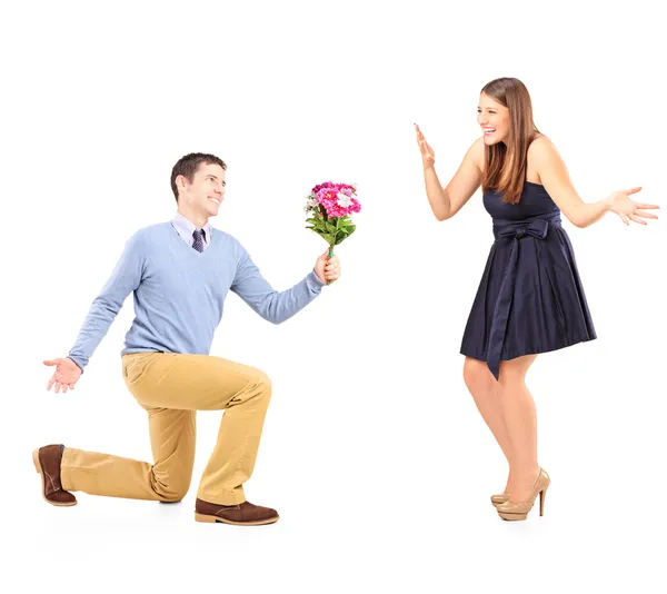 Masculino ajoelhado com flores — Fotografia de Stock