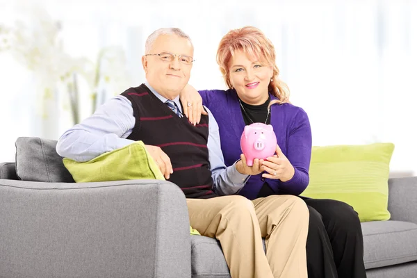 Homem e mulher segurando porquinho banco — Fotografia de Stock