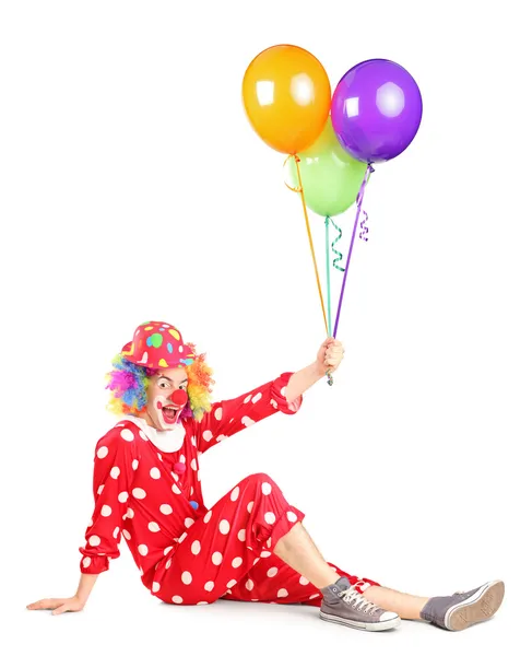 Clown seduto e con palloncini in mano — Foto Stock