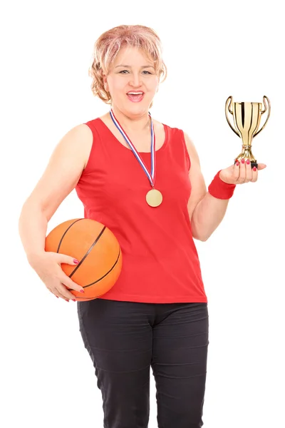 Женщина держит трофей и баскетбол — стоковое фото