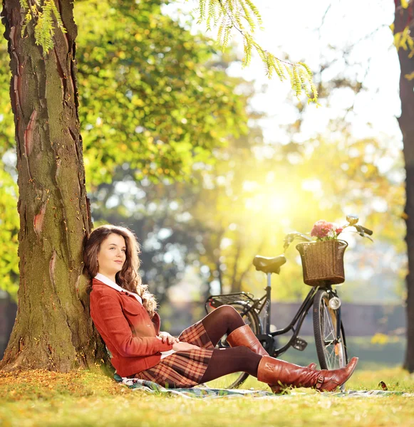 Feminino com bicicleta relaxante em um parque — Fotografia de Stock