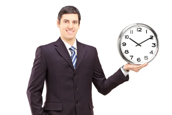 Young man in suit holding a clock — Stock Photo, Image