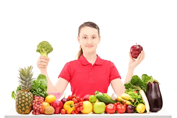 Adolescente sosteniendo manzana y brócoli — Foto de Stock