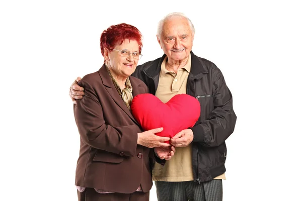 Hombre y mujer sosteniendo almohada de corazón — Foto de Stock