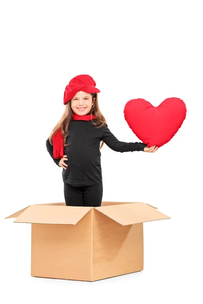 Girl standing in box and holding heart — Stock Photo, Image