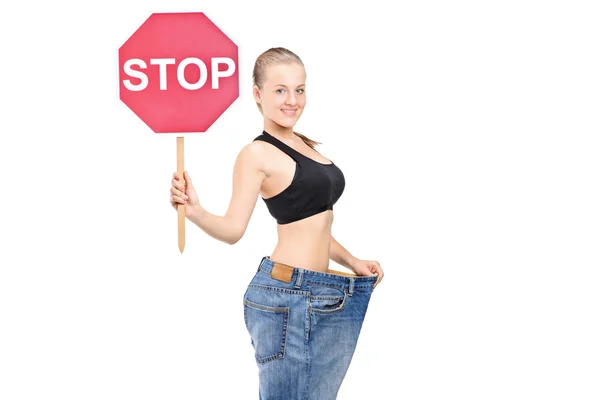 Niña de pérdida de peso sosteniendo parada de señal de tráfico —  Fotos de Stock