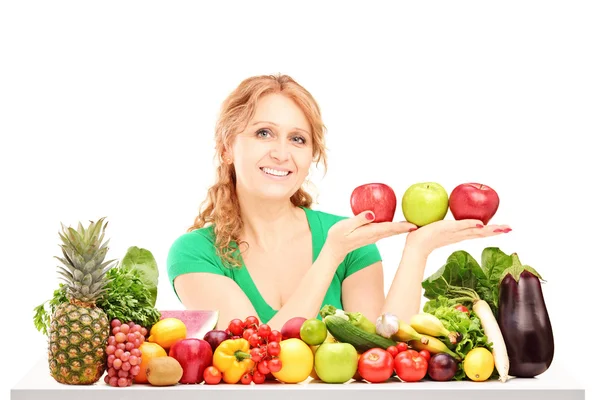 Woman behind table full of fruit and vegetable Royalty Free Stock Photos