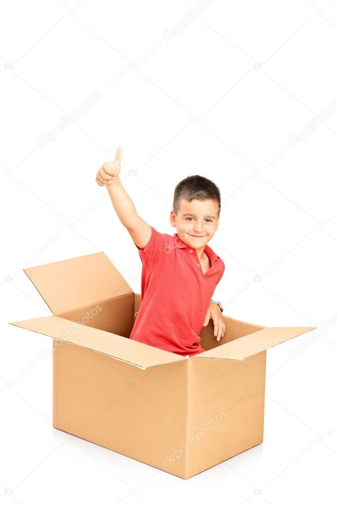 Child in paper box giving thumb up