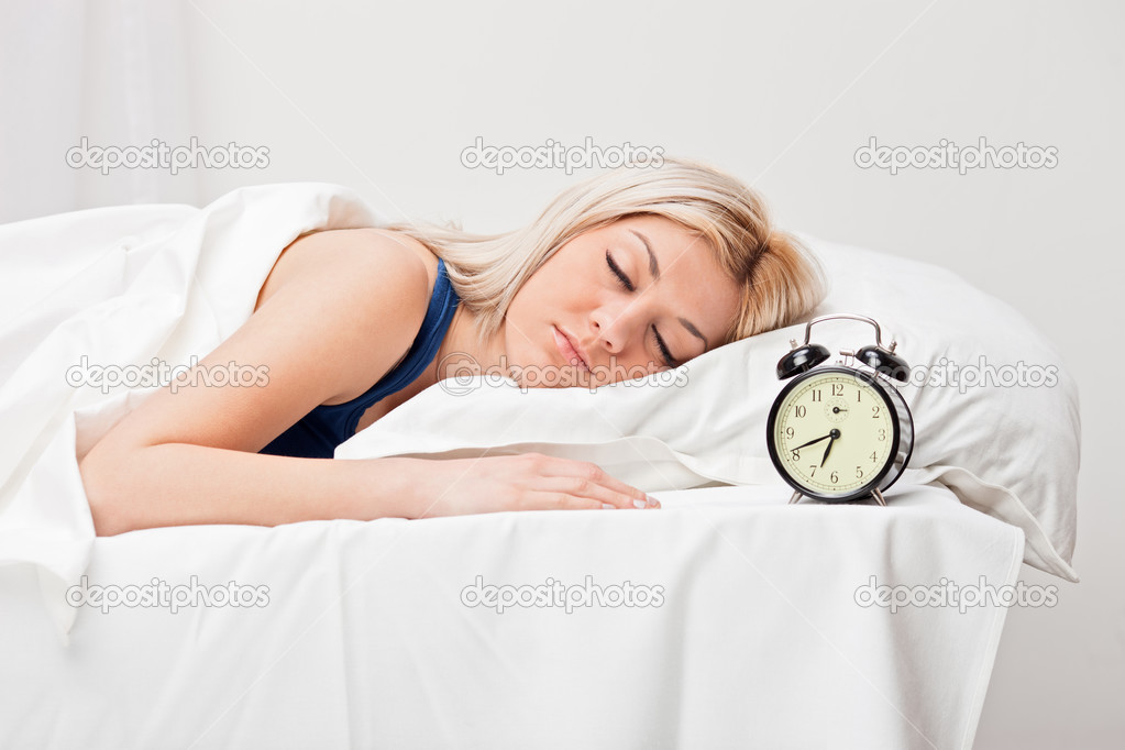 Woman and alarm clock in bedroom