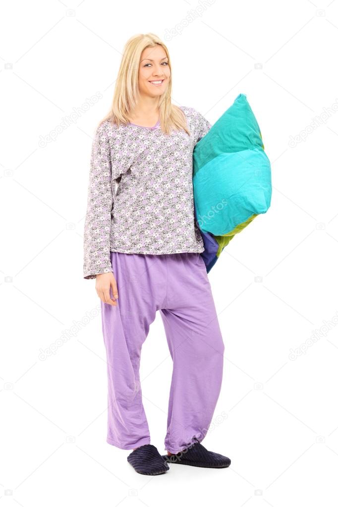 Blond girl in pajamas holding pillow