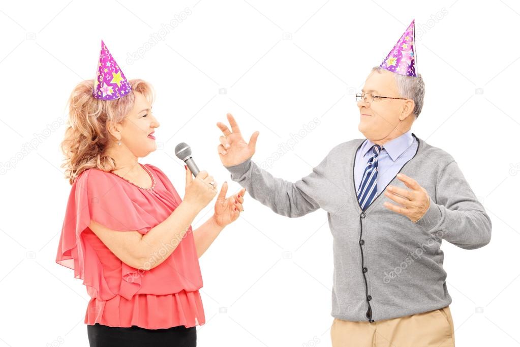 Couple with party hats dancing and singing