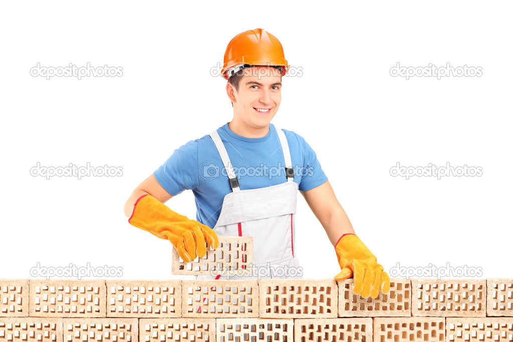 Male construction worker holding brick