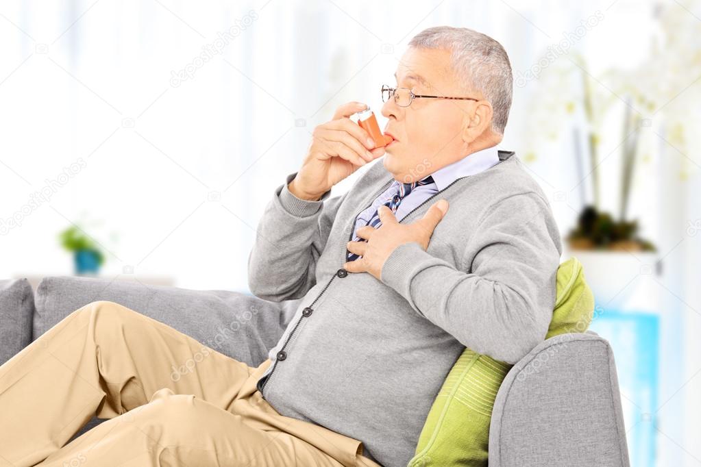 Man taking asthma treatment with inhaler