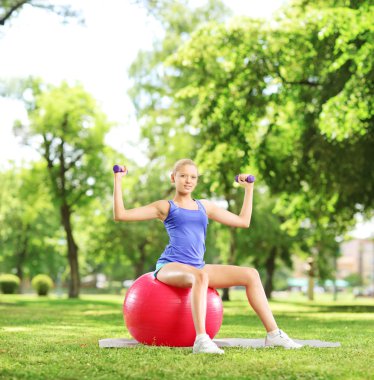 topun üzerinde oturan atlet