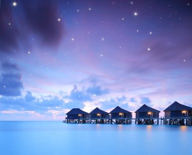 Starry skies over water villa cottages clipart