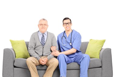 genç doktor ve kıdemli beyefendi kanepeye poz 