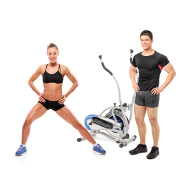 kadın ve erkek sporcular cross trainer makine yanında poz