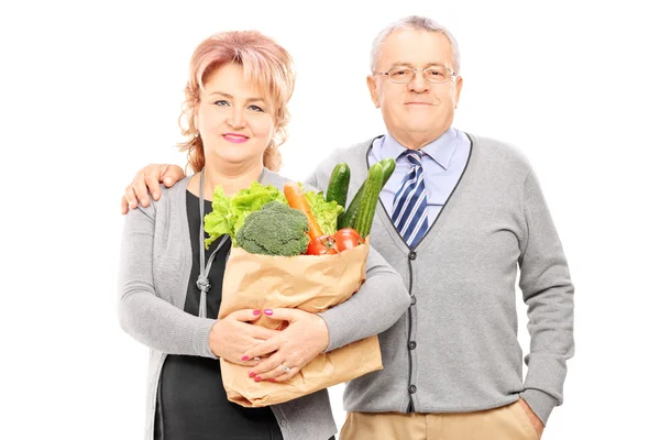 Couple holding paper bag full of groceries — Stock Photo, Image